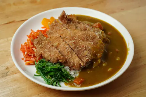 Tonkatsu cortado en tiras servido con col rallada